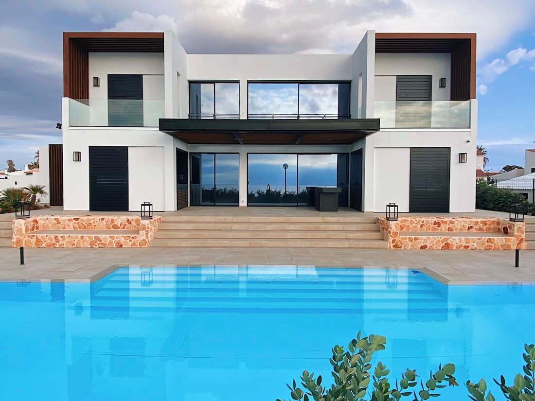 Large rectangular pool with an infinity edge beneath a dramatic sky